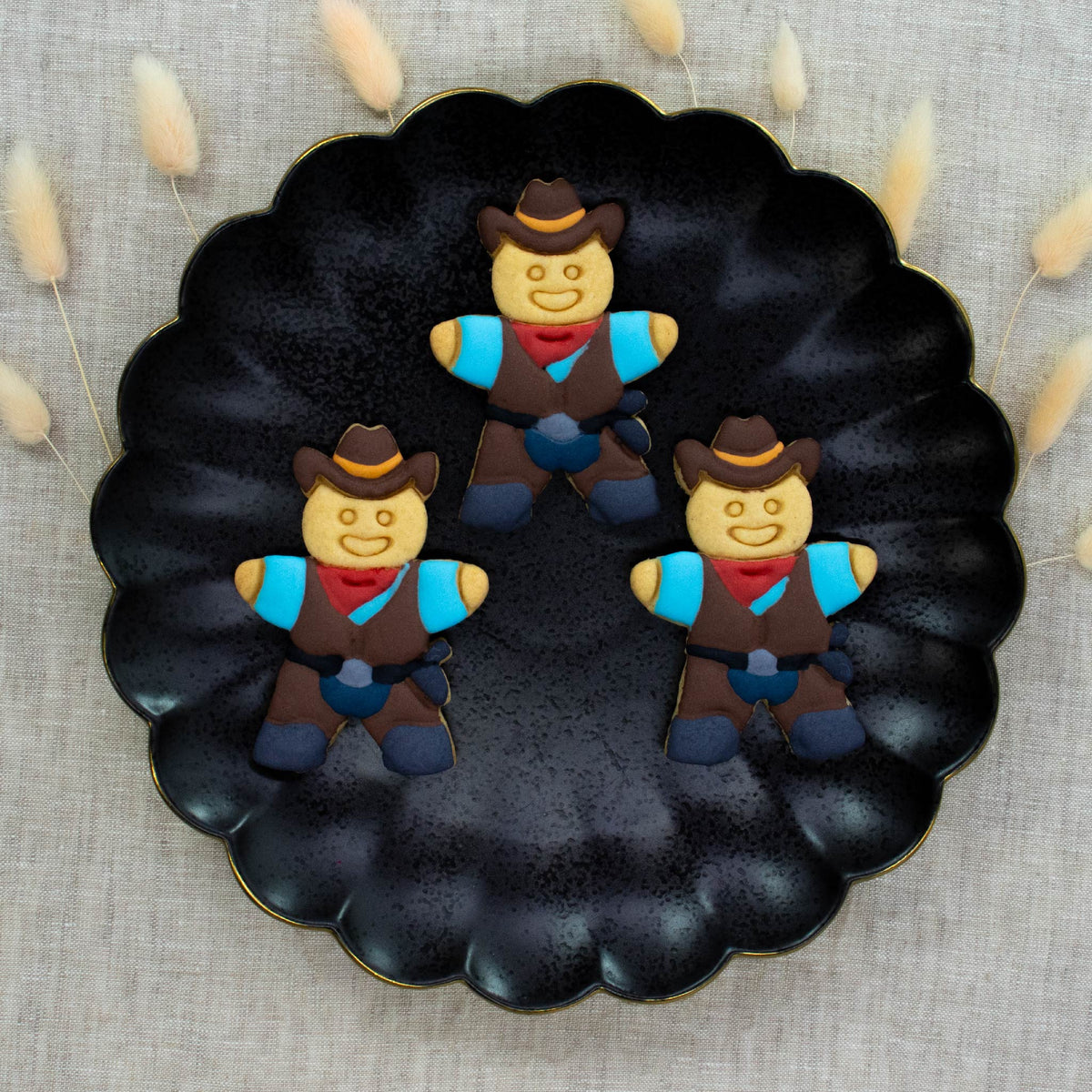 cowboy cookies colored with royal icing made with bakerlogy gingerbread cowboy cookie cutter