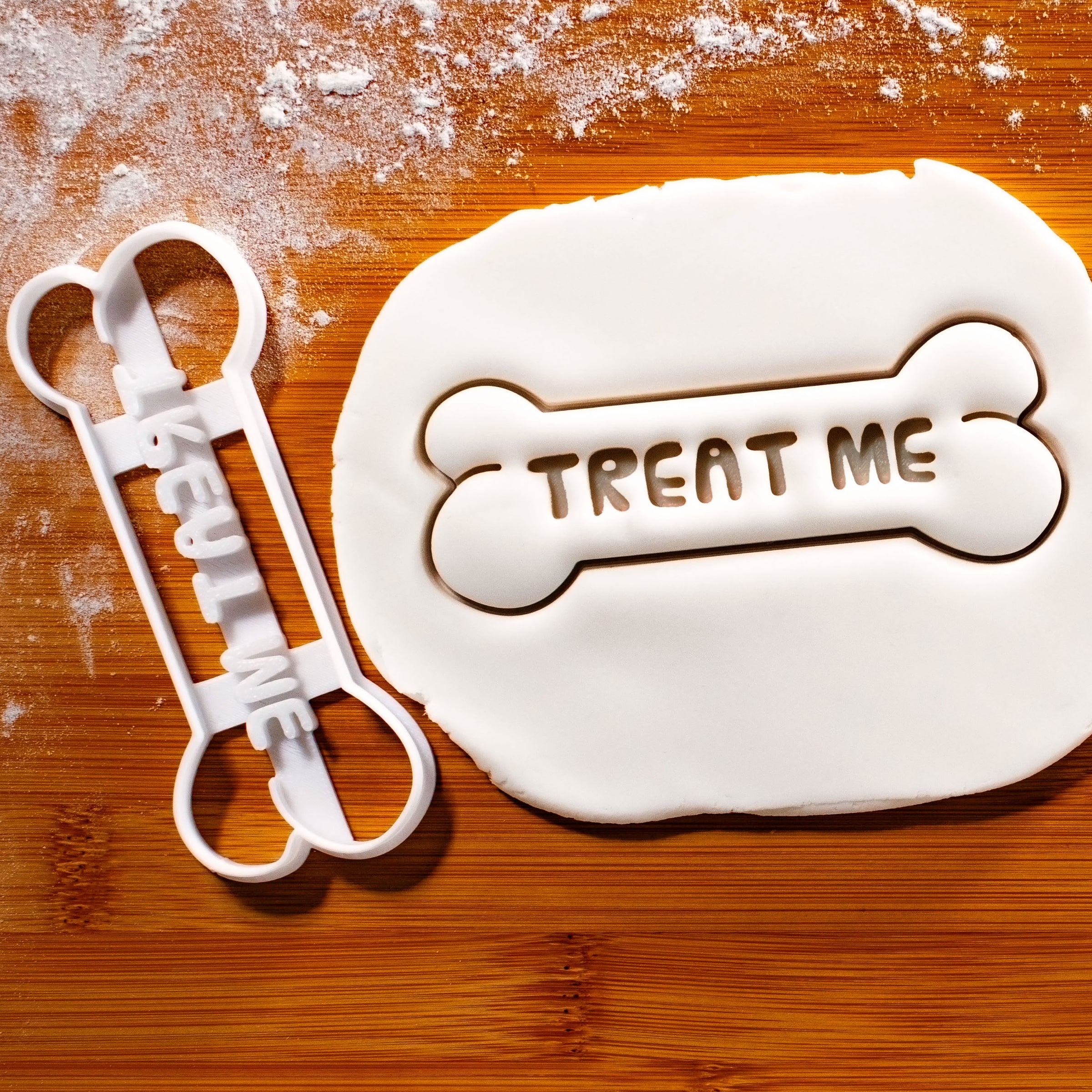 TREAT ME Dog Bone Cookie Cutter pressed on white fondant icing - Bakerlogy