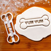 YUM YUM Dog Bone Cookie Cutter pressed on white fondant icing to show imprints - bakerlogy
