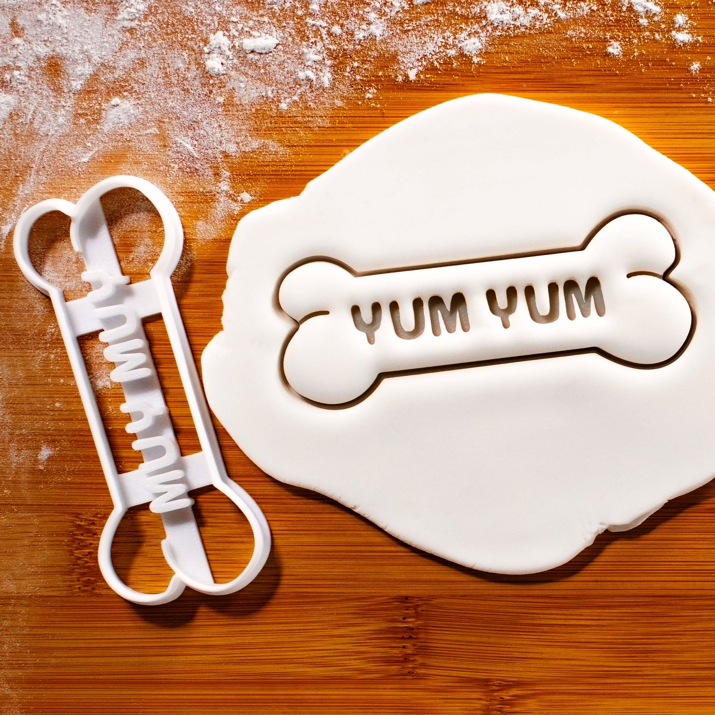 YUM YUM Dog Bone Cookie Cutter pressed on white fondant icing to show imprints - bakerlogy