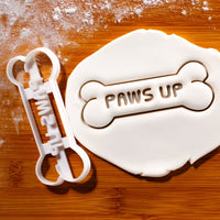 PAWS UP Dog Bone Cookie Cutter pressed on white fondant icing to show imprints - bakerlogy