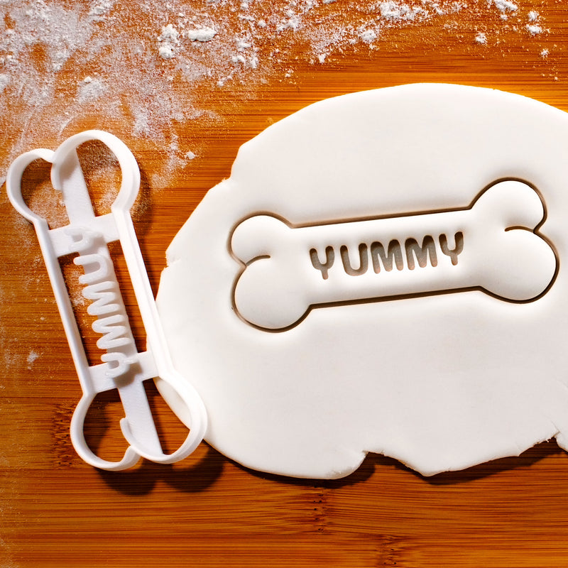 YUMMY Dog Bone Cookie Cutter pressed on white fondant icing - bakerlogy