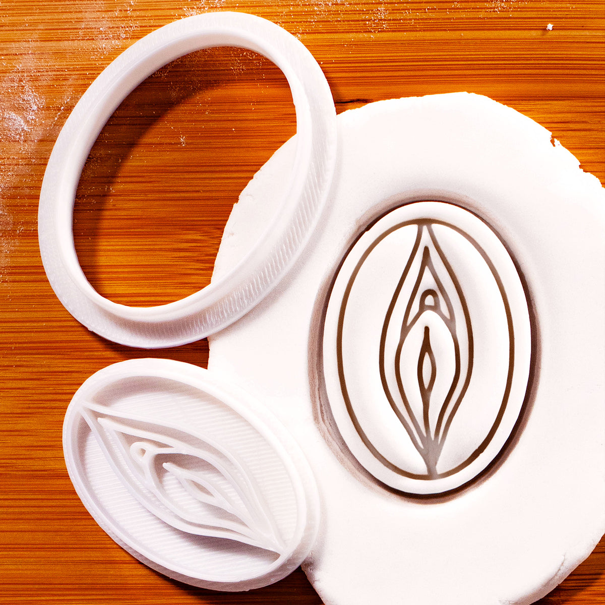 detailed vulva mini cookie cutter & stamp pressed on white fondant.