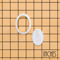 detailed mini vulva cookie cutter and stamp on inch size grid reference