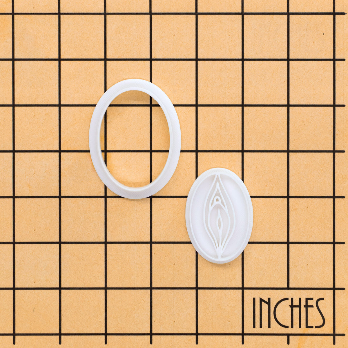 detailed mini vulva cookie cutter and stamp on inch size grid reference