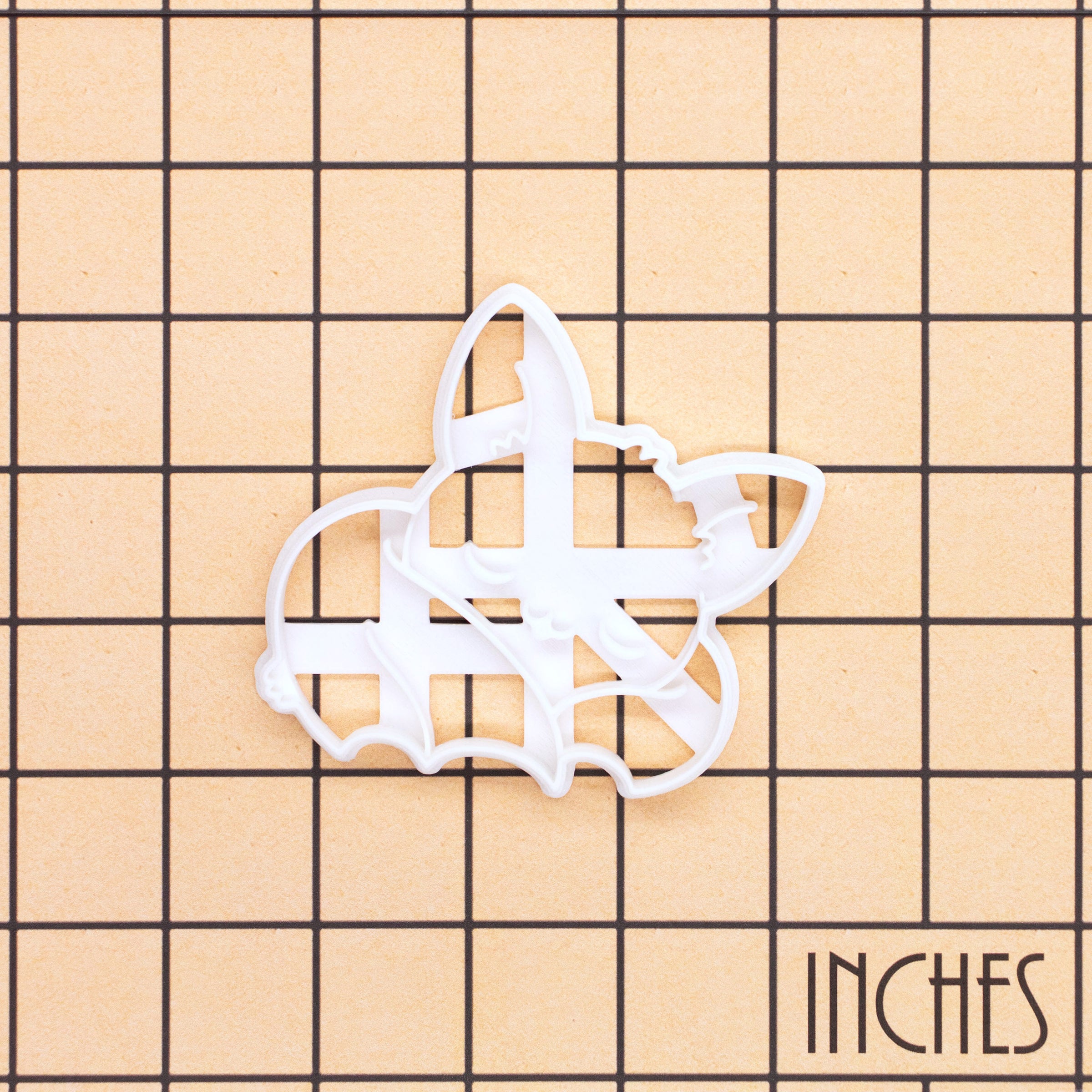 Sleeping Chibi Bat Cookie Cutter shown on an inch measurement grid for size reference