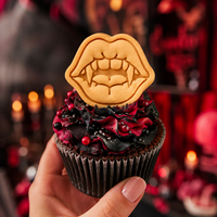 Vampire fang lips cookie used as a Halloween cupcake topper with red and black gothic frosting