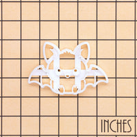 Sitting chibi bat Halloween cookie cutter shown on an inch grid for size reference