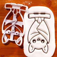 Hanging chibi bat cookie cutter creating an upside-down bat with folded wings for Halloween baking