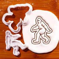 Bigfoot mini cookie cutter and stamp beside a detailed Sasquatch impression in fondant