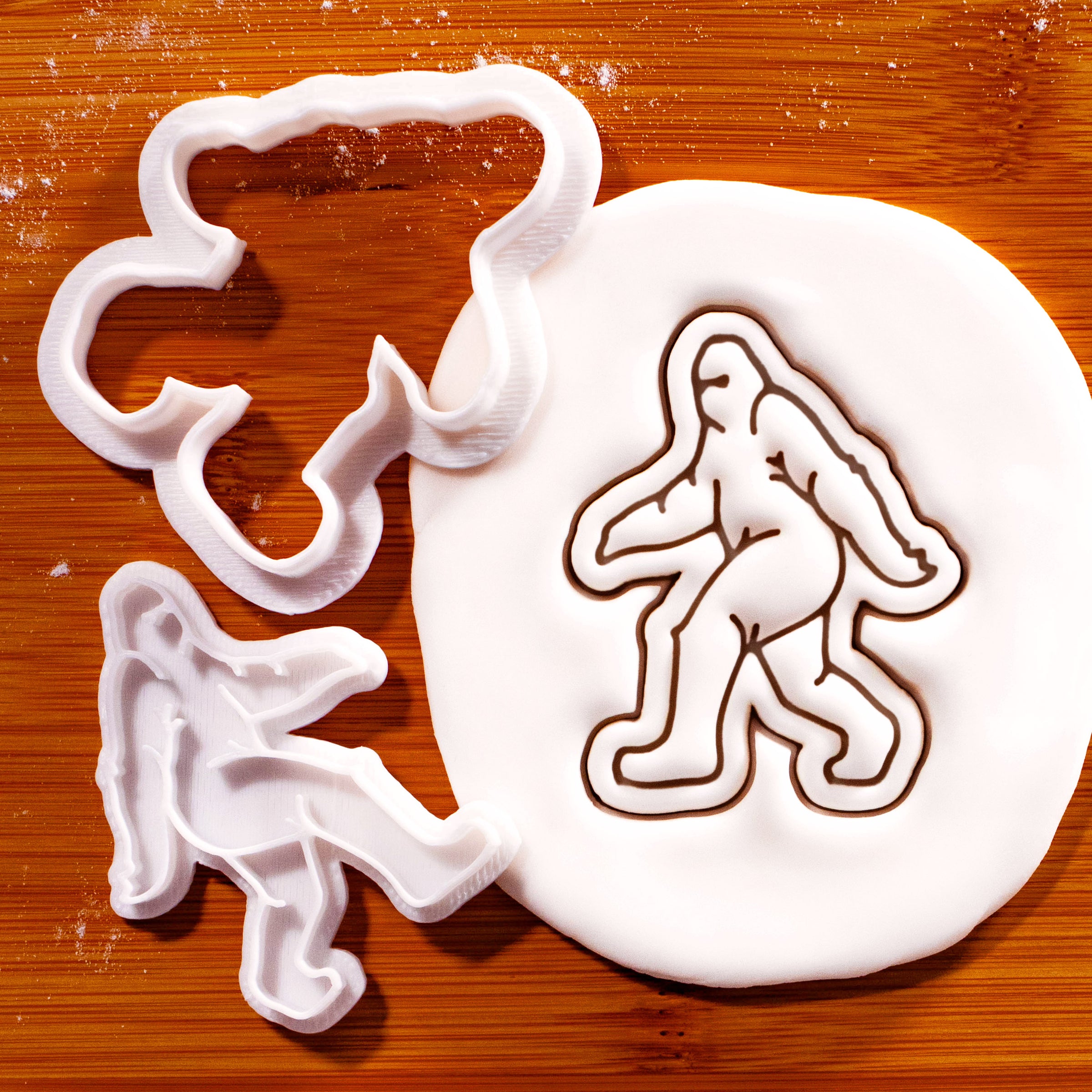 Bigfoot mini cookie cutter and stamp beside a detailed Sasquatch impression in fondant