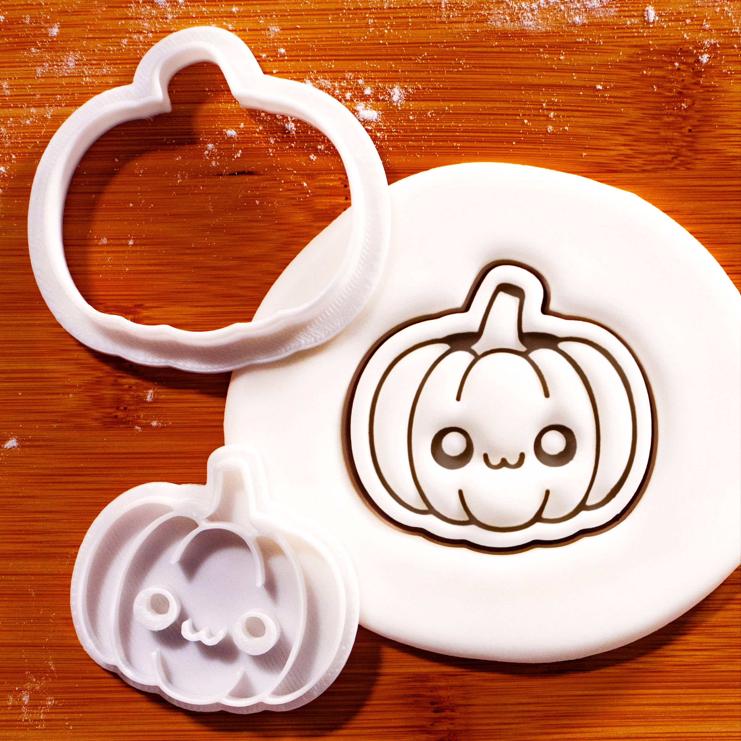 Kawaii pumpkin mini cookie cutter and stamp beside a detailed fondant pumpkin impression
