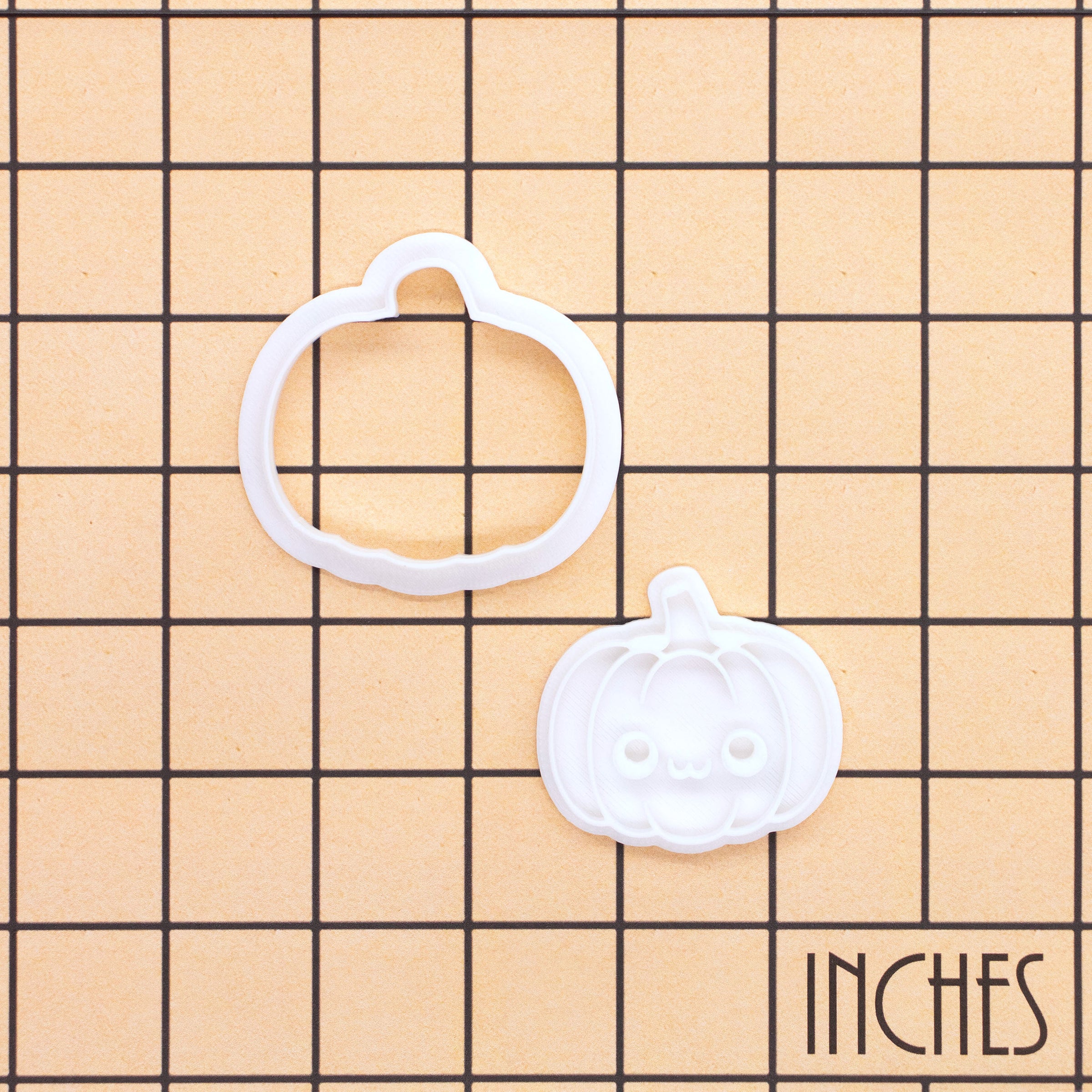 Kawaii pumpkin mini cookie cutter and stamp set shown on an inch measurement grid