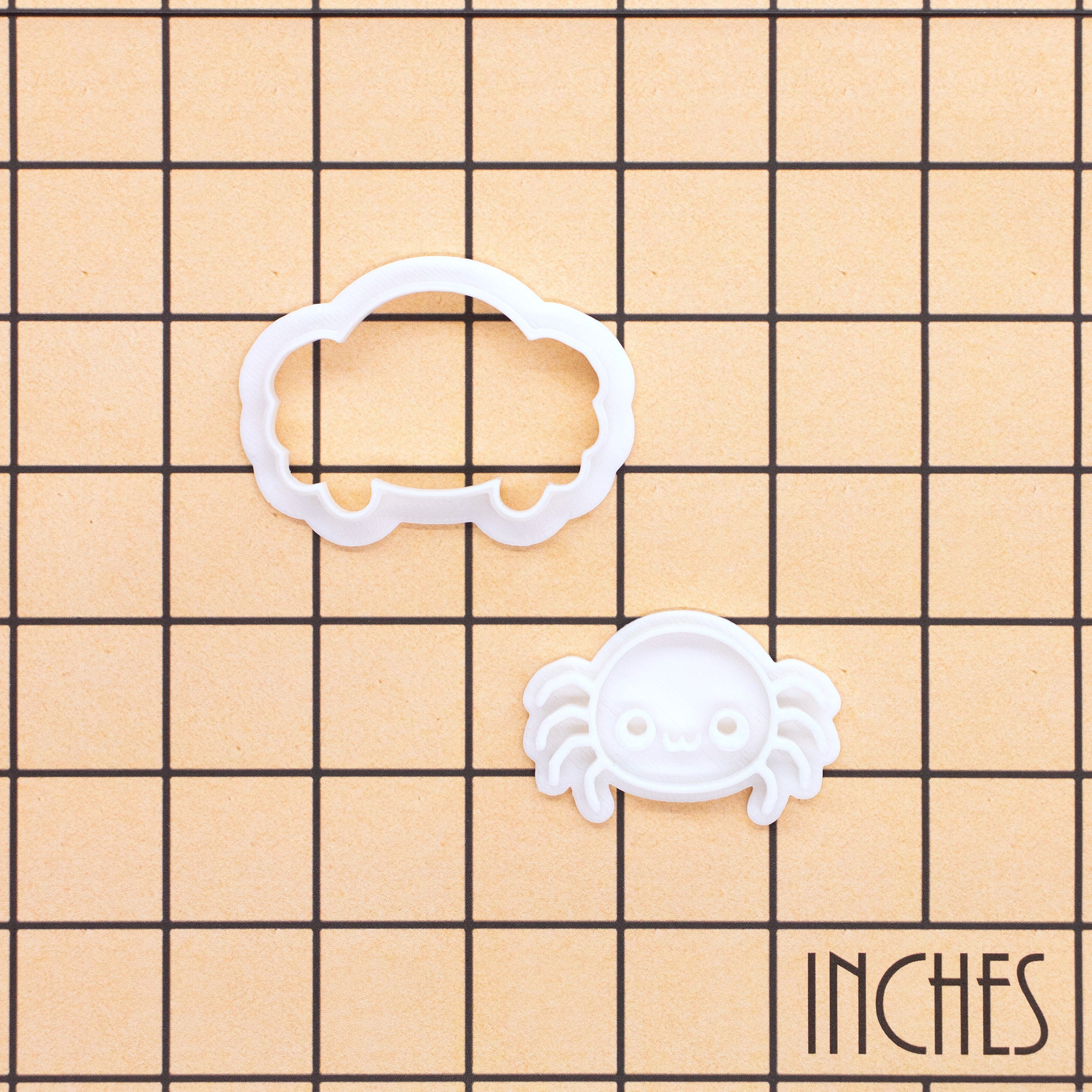 Chibi spider mini cookie cutter and impression stamp shown on an inch grid
