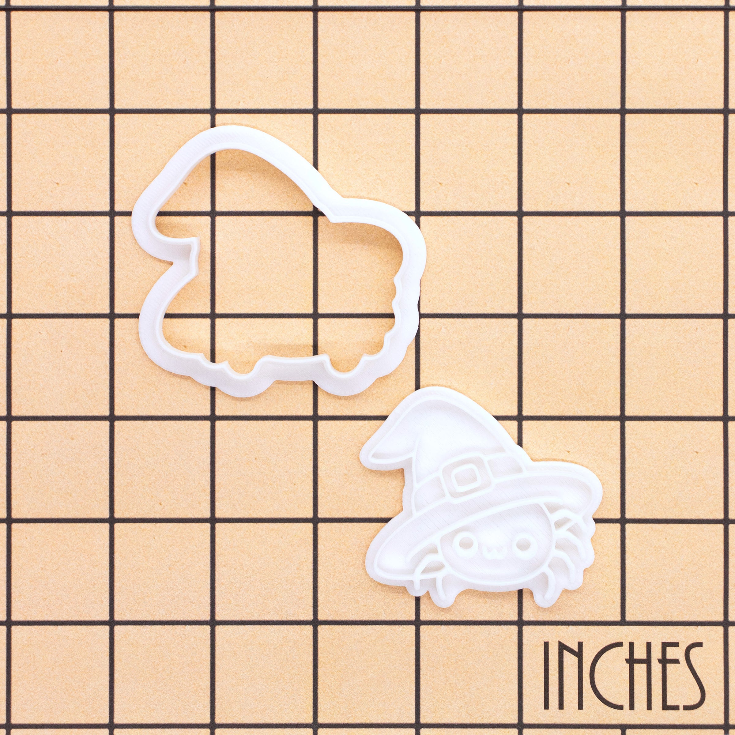 Witchy spider mini cookie cutter and stamp set on an inch grid
