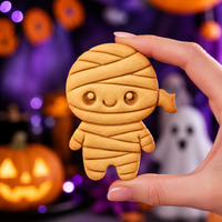 Chibi mummy embossed cookie held against Halloween party background