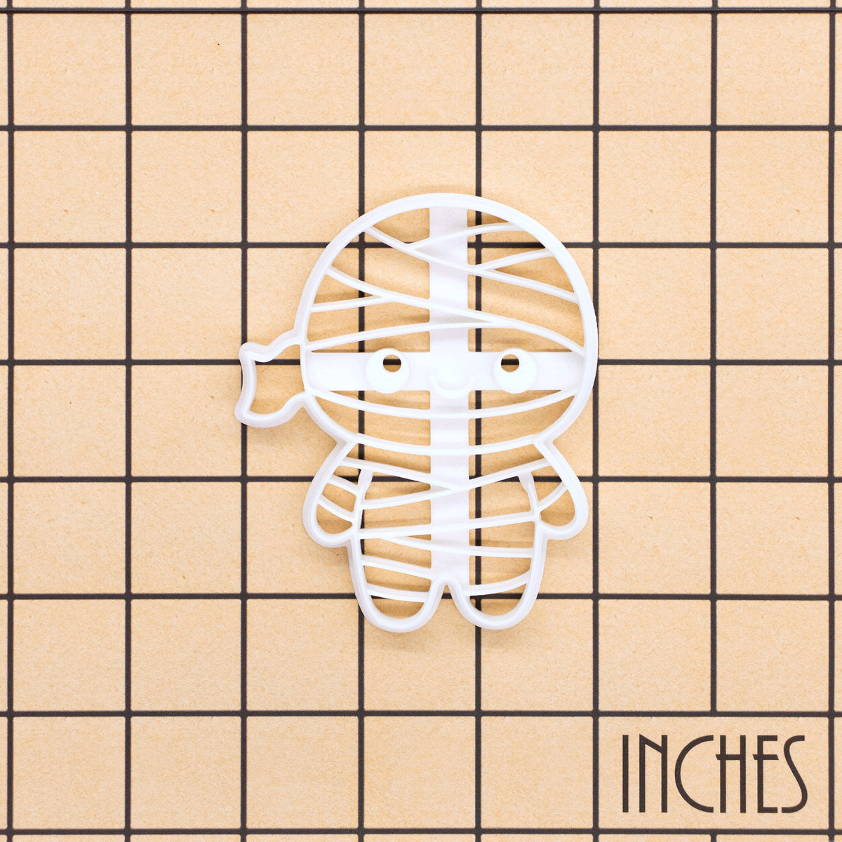 Chibi mummy cookie cutter on an inch measurement grid