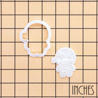 Chibi mummy mini cookie cutter and impression stamp shown on inch measurement grid