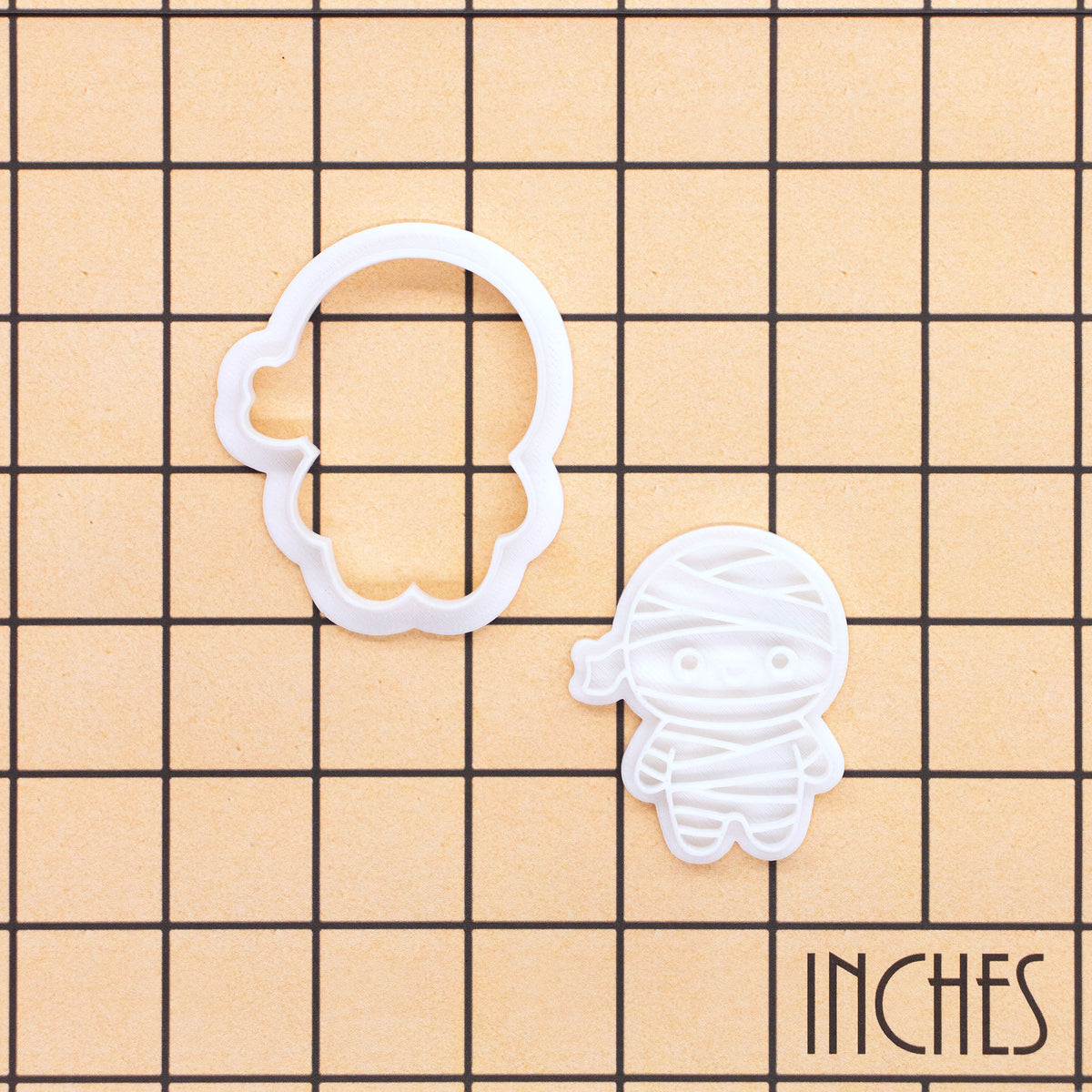 Chibi mummy mini cookie cutter and impression stamp shown on inch measurement grid