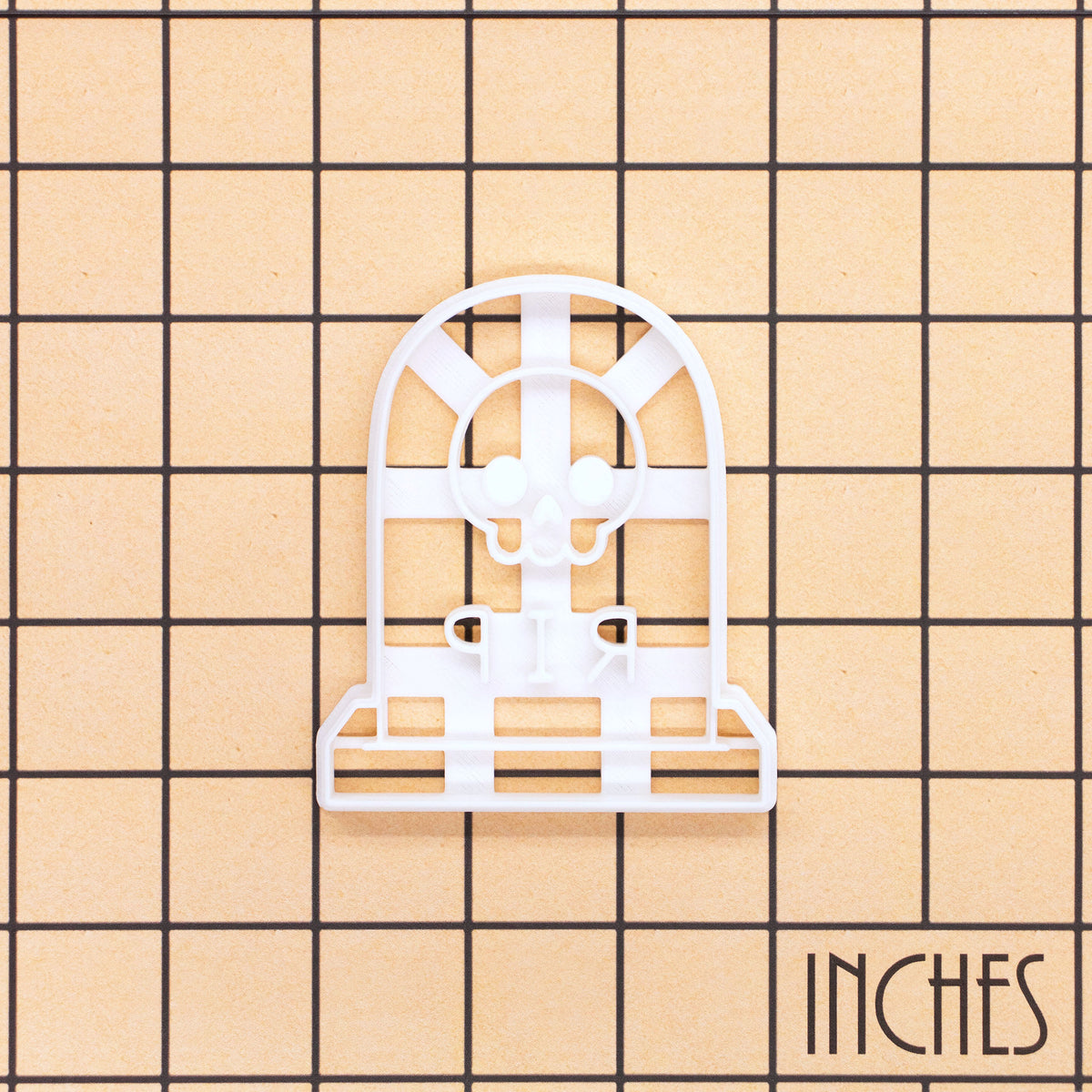 RIP Tombstone with Skull cookie cutter shown on inch measurement grid