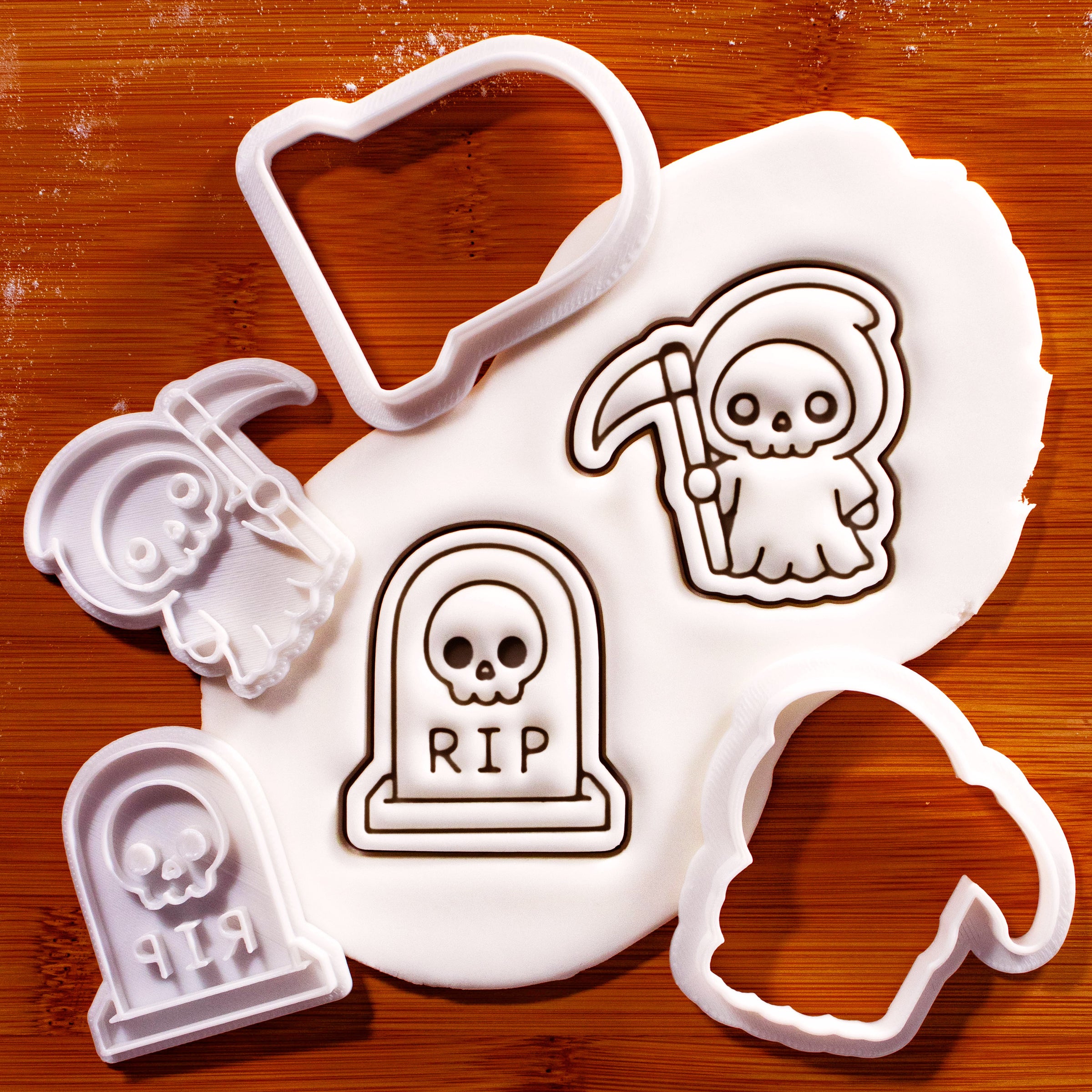 Grim Reaper and skull tombstone mini cookie cutter and stamp set with fondant impressions on a wooden board