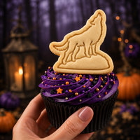 Howling wolf stamped cookie topper on purple Halloween cupcake with spooky forest background