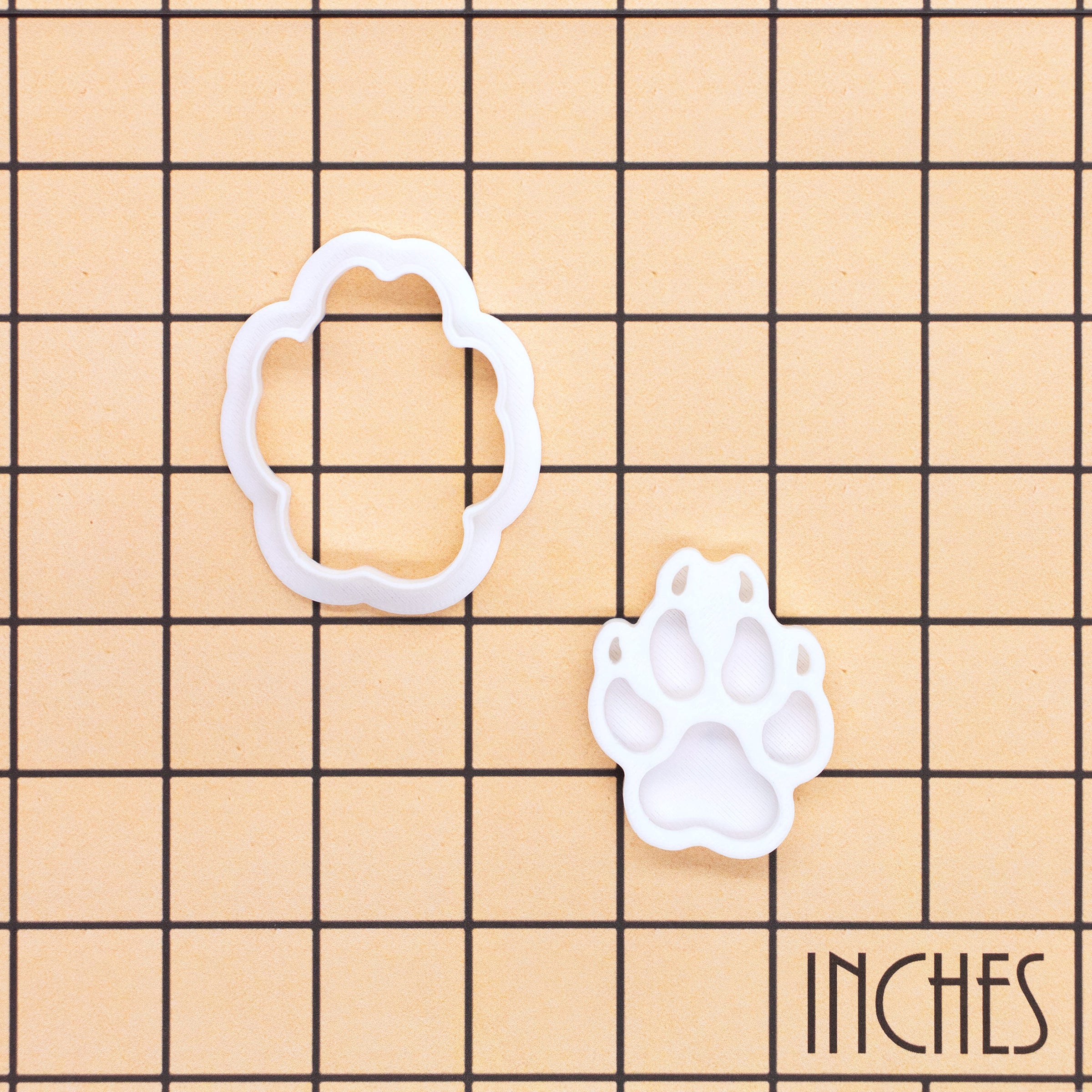Wolf Paw Print mini cookie cutter and matching stamp shown on inch measurement grid