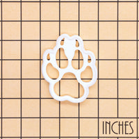 Wolf paw print mini cookie cutter and stamp shown on inch measurement grid