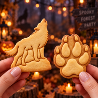 Howling wolf and wolf paw print cookies held against a woodland Halloween background