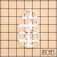 Kawaii raven on skull Halloween cookie cutter shown on an inch measurement grid