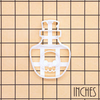Kawaii poison potion skull bottle cookie cutter shown on an inch measurement grid