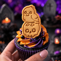 Raven on skull mini Halloween cookie topper on an orange and purple frosted cupcake