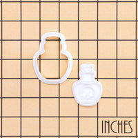 Poison potion mini cookie cutter and skull bottle stamp shown on an inch measurement grid