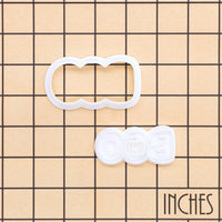 BOO pumpkin mini cookie cutter and stamp set shown on an inch measurement grid
