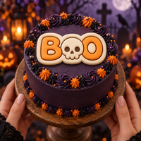 BOO skull fondant decoration on a purple Halloween cake with orange and black buttercream