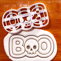 BOO skull cookie cutter beside embossed fondant showing Halloween skull lettering design