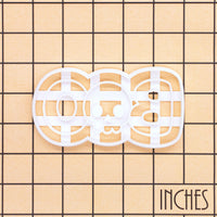 BOO skull Halloween cookie cutter shown on an inch measurement grid