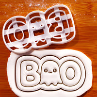 White BOO cute ghost cookie cutter beside embossed fondant showing the Halloween ghost lettering design