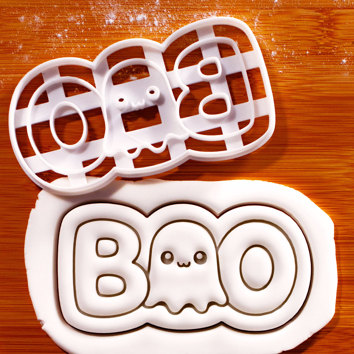 White BOO cute ghost cookie cutter beside embossed fondant showing the Halloween ghost lettering design