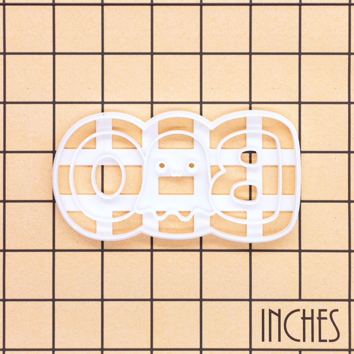 BOO cute ghost cookie cutter on an inch grid showing the size and 3D-printed cutter details