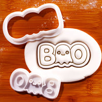 White BOO Cute Ghost mini cookie cutter and stamp set with fondant impression on a wooden board