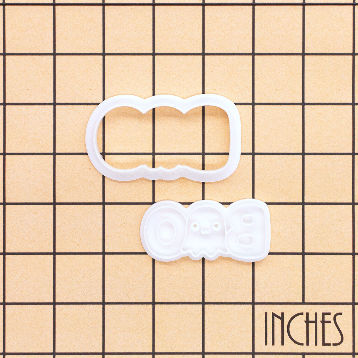 BOO Cute Ghost mini cookie cutter and stamp set on an inch grid showing the size of the Halloween baking tool