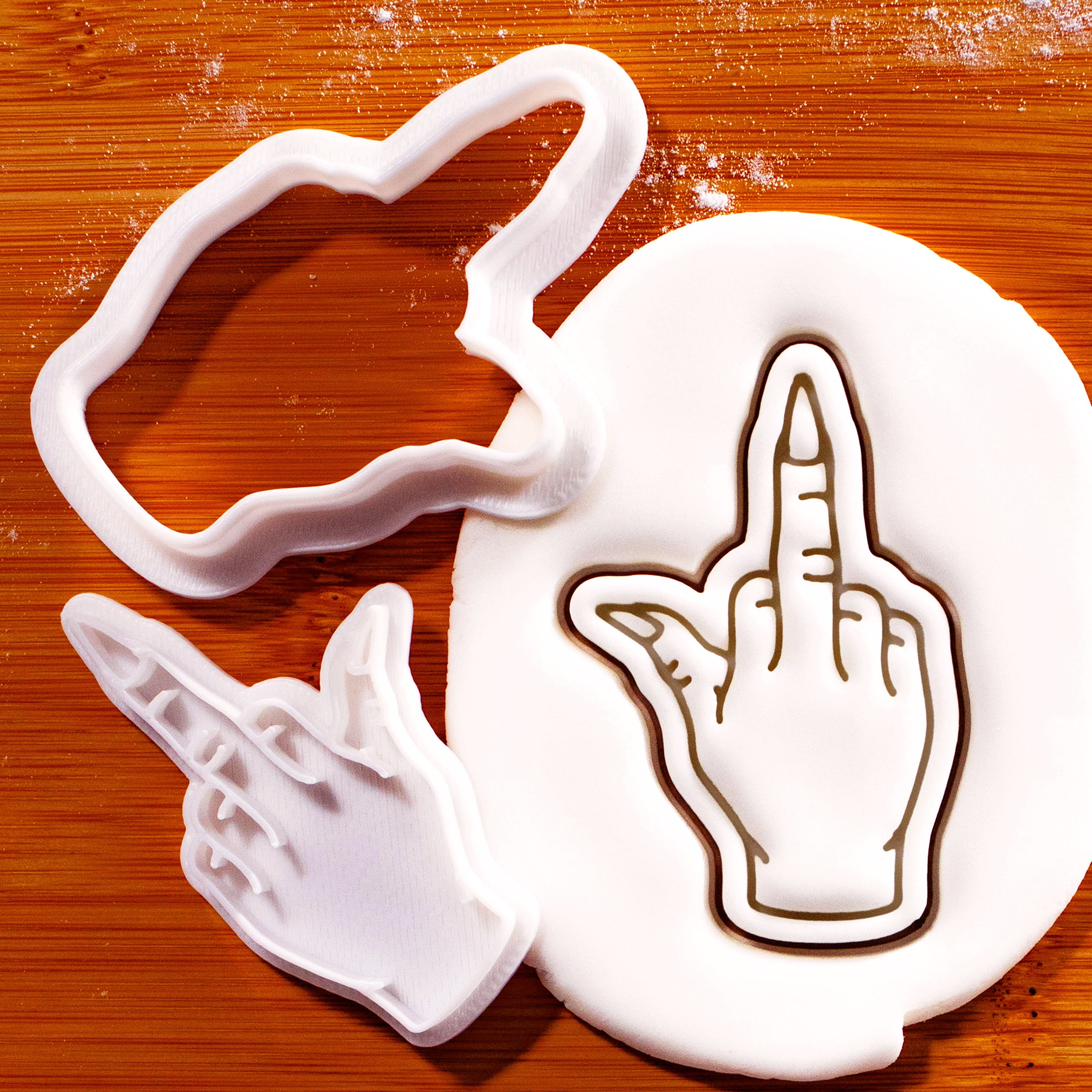 Witchy middle finger mini cookie cutter and stamp set beside detailed hand impression in fondant