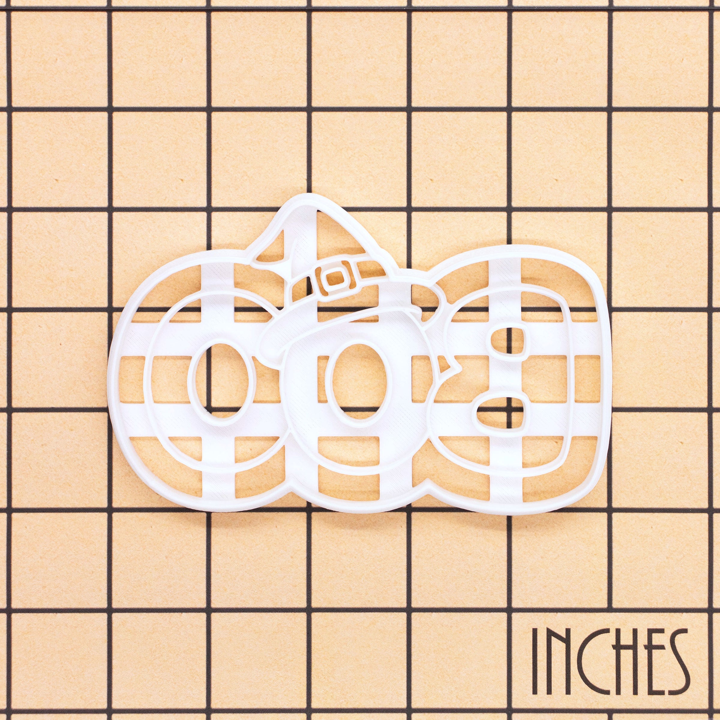 BOO witch hat cookie cutter shown on inch measurement grid for size reference