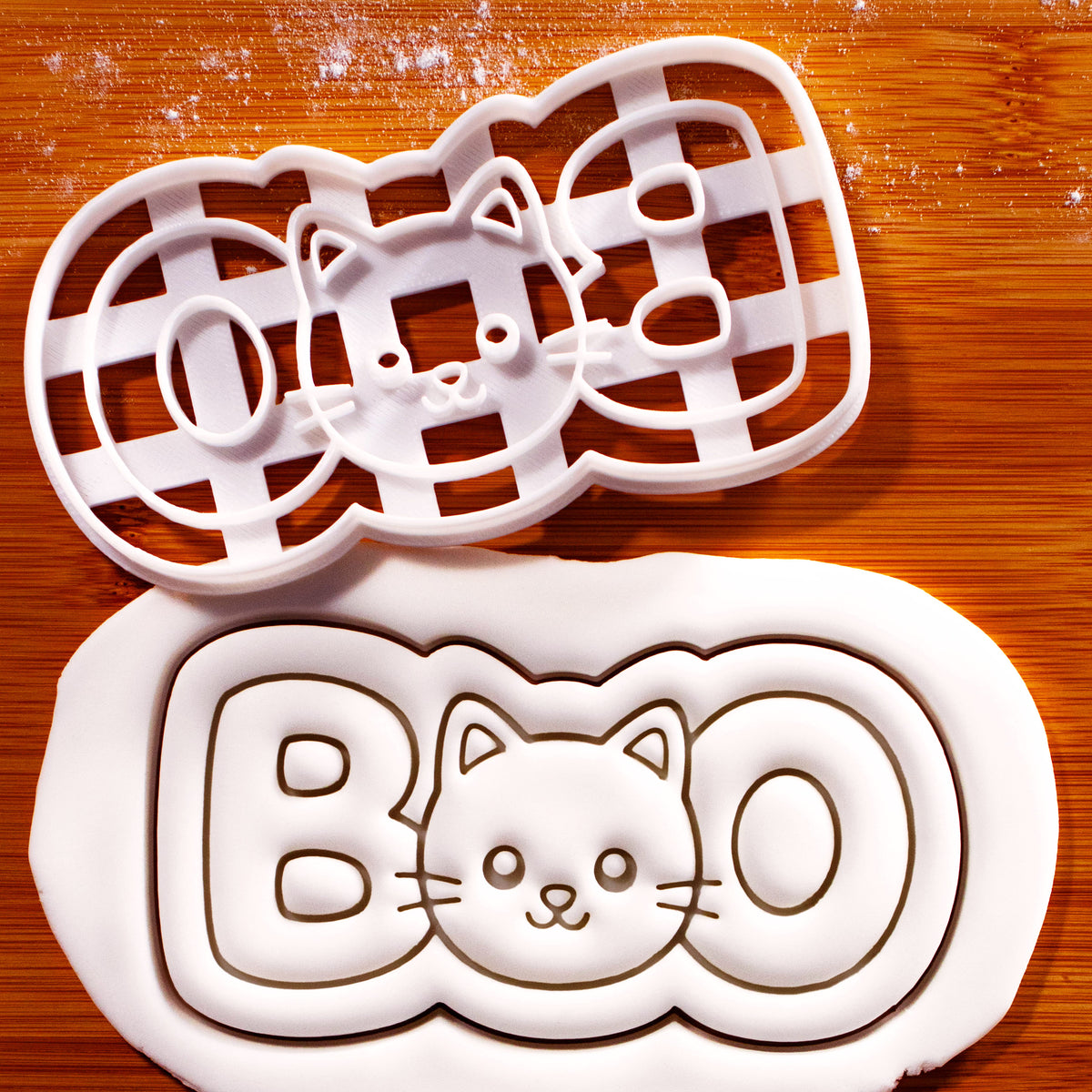 BOO cat face cookie cutter beside stamped fondant showing detailed cat face and BOO lettering