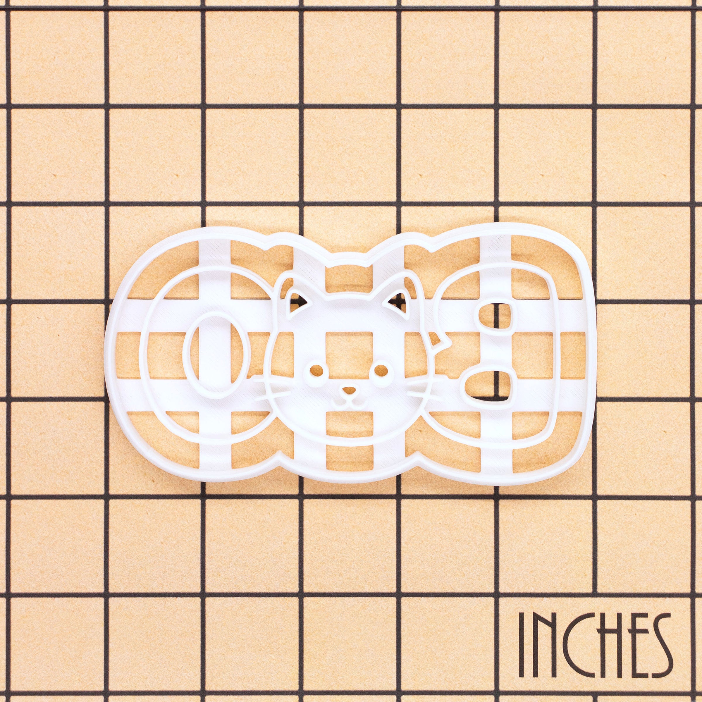 BOO cat face cookie cutter shown on inch measurement grid for size reference