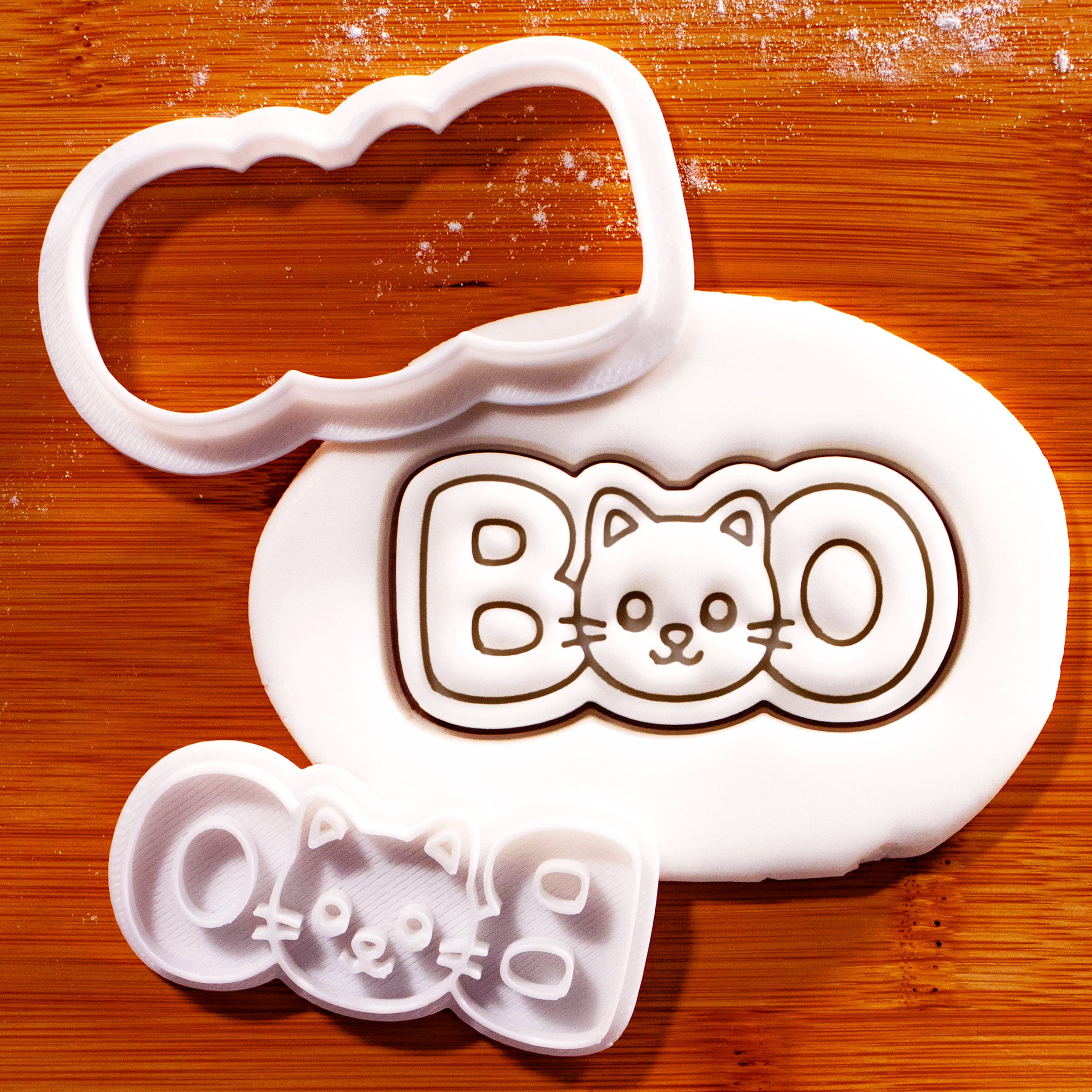BOO cat face mini cookie cutter and stamp set beside fondant impression on wooden board
