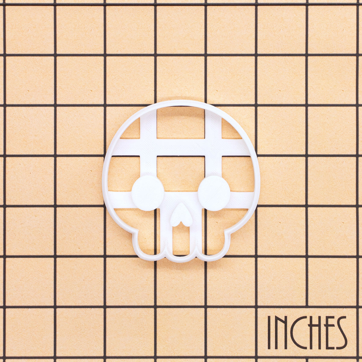 Cute Skull front view cookie cutter and embosser shown on an inch measurement grid