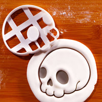 Cute Skull side view cookie cutter with embossed skull impression in white fondant on a wooden board