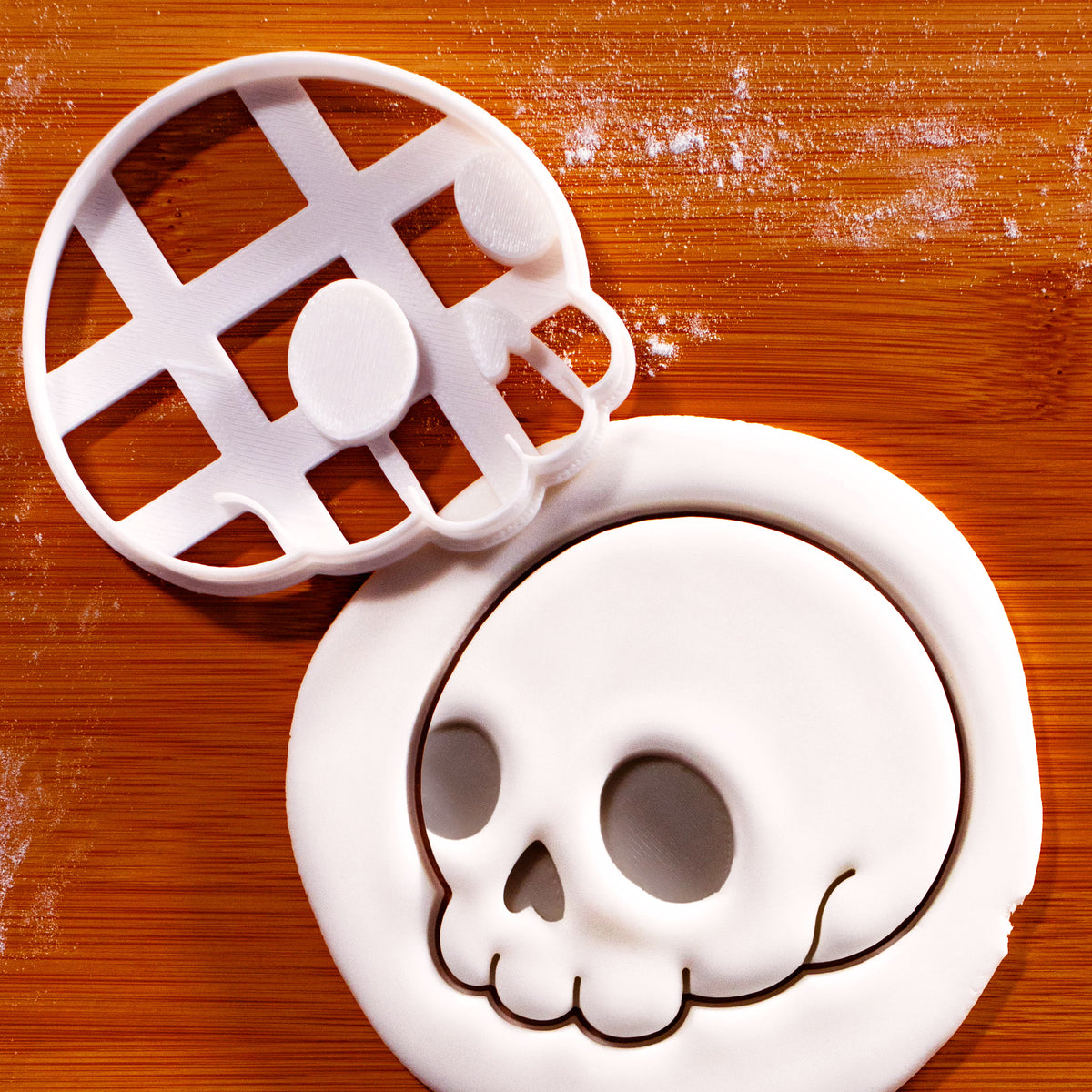 Cute Skull side view cookie cutter with embossed skull impression in white fondant on a wooden board